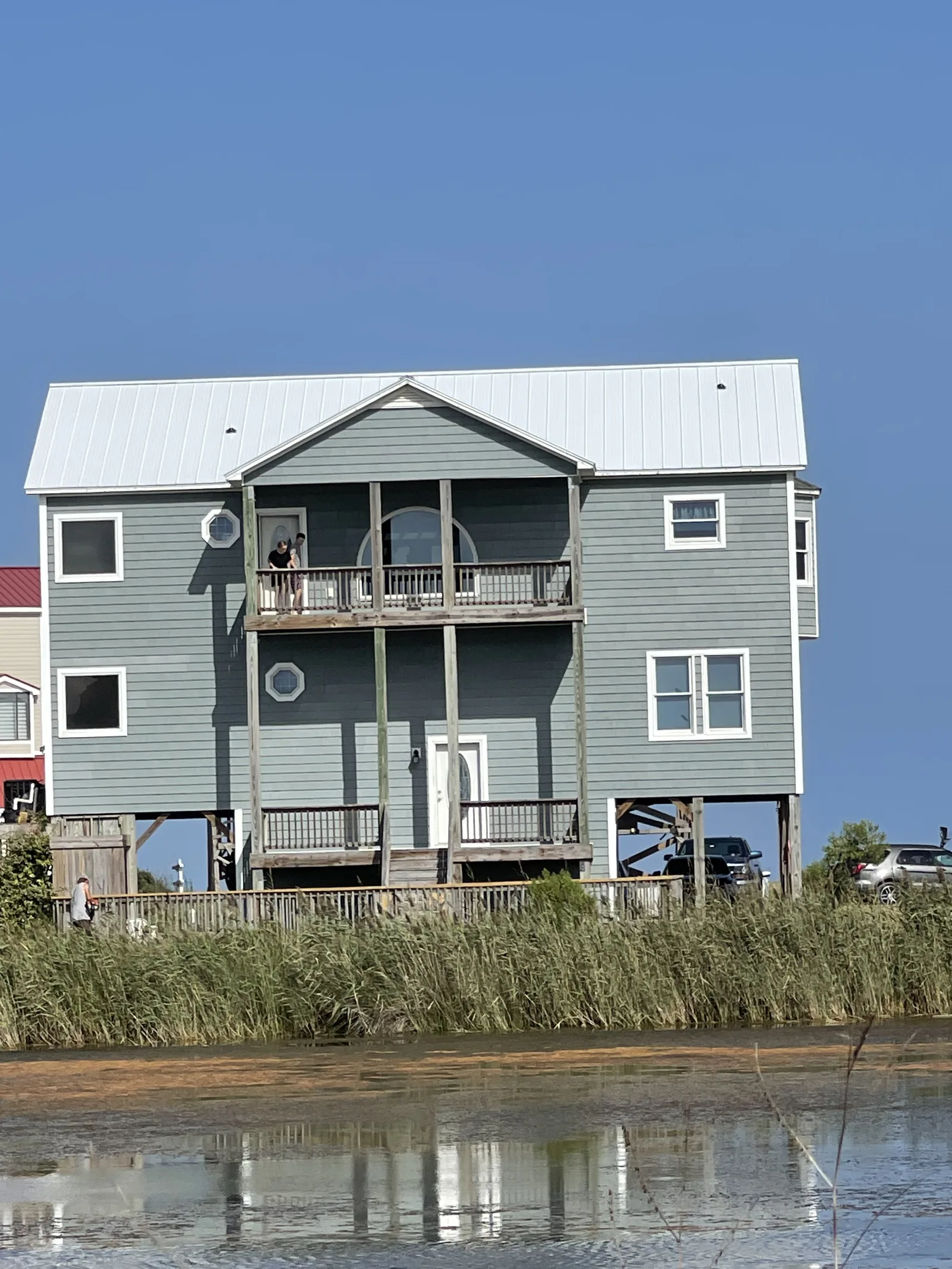 A three-storey elevated coastal home with wraparound balconies