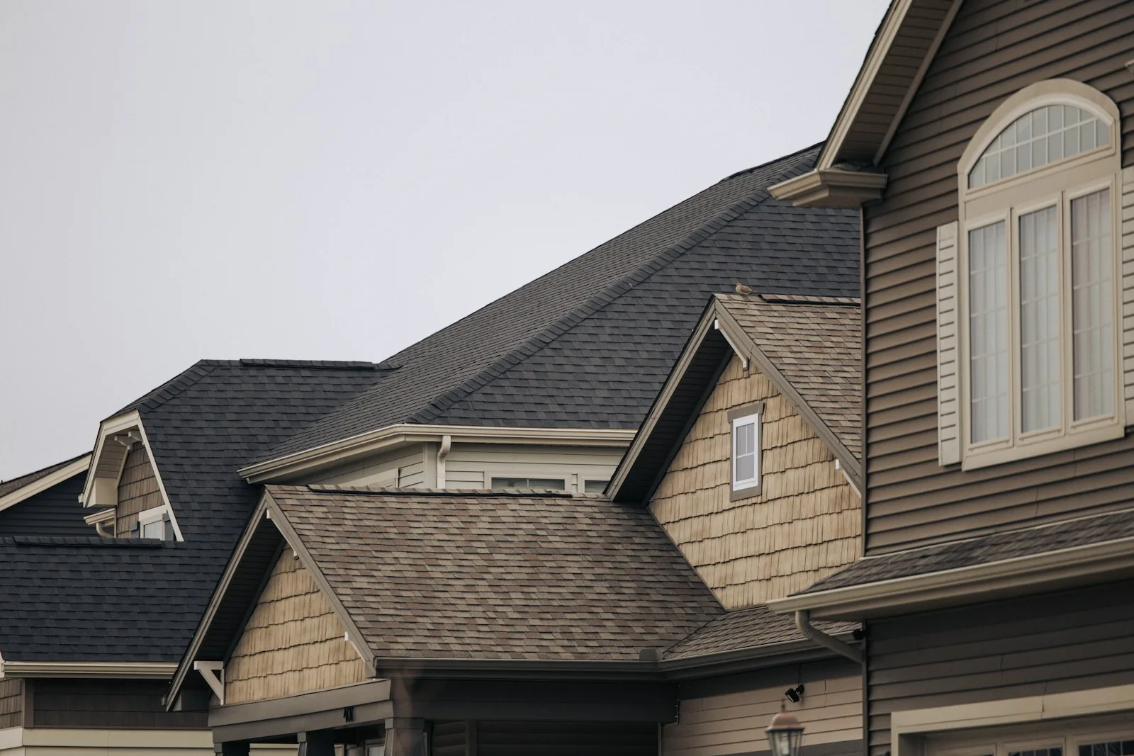 A finished asphalt-shingle roof over gables and dormers
